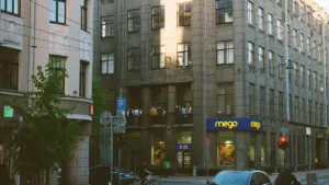 Rīgas pilsētas iela ar daudzstāvu dzīvojamām ēkām un ikdienas satiksmi.