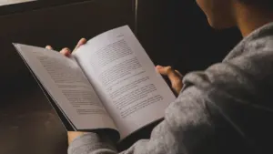Cilvēks lasa grāmatu, kas simbolizē garaspēku un iekšējo mieru steidzīgā ikdienas ritmā.