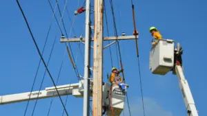Elektromontieri veic elektropārvades līnijas remontdarbus, izmantojot pacēlāju skaidrā dienas laikā.